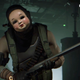 A person in a doll mask wields a shotgun.